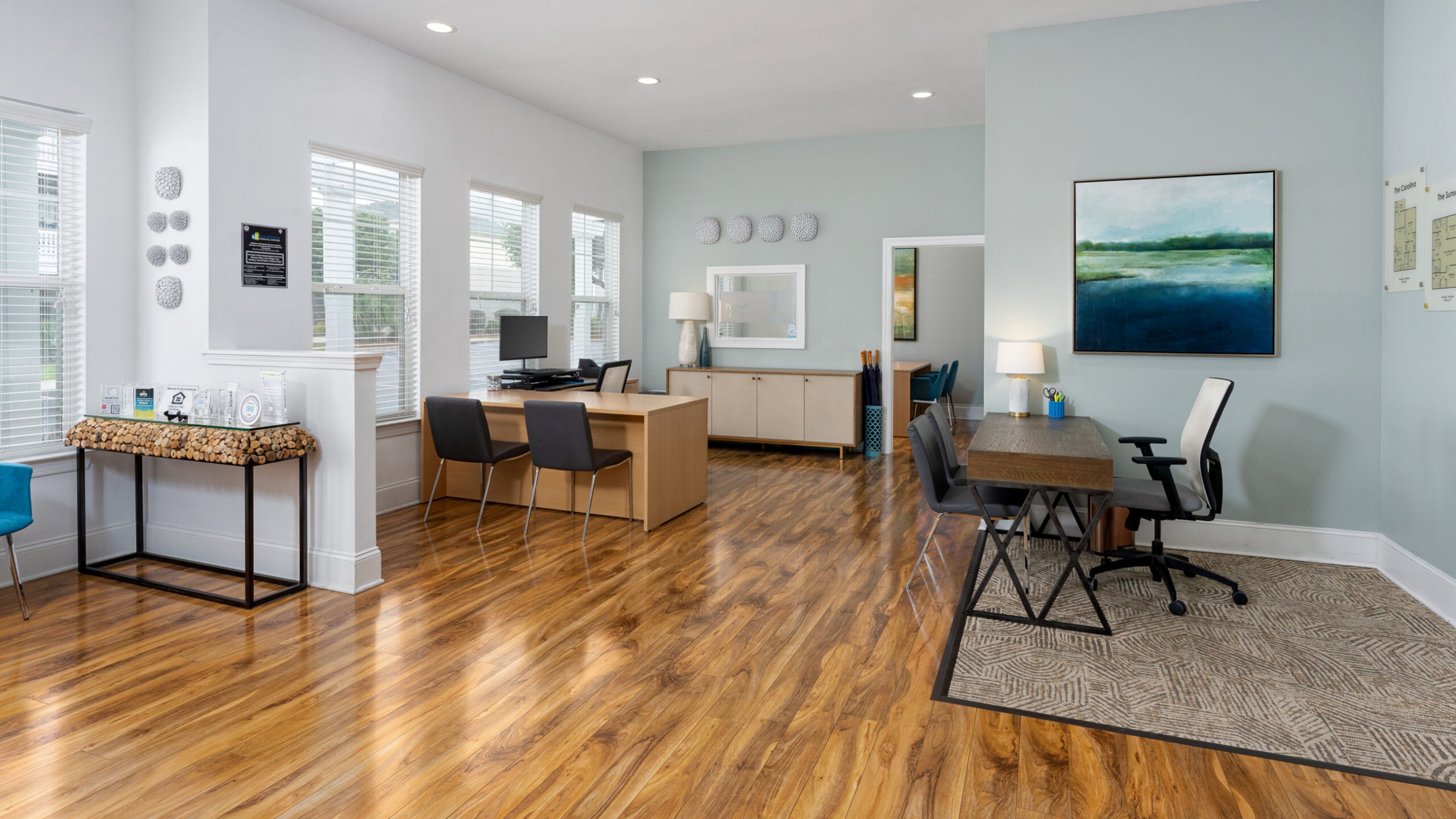Hawthorne at Murrayville cyber cafe sectional couch with round wooden coffee table and wall game in a room with windows and modern light fixture.